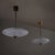 Pair of pendant lights with elongated brass stems and wall mounts, featuring lens-shaped bodies in pressed crystal glass....