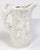 Rich ivory glazed pitcher in the style of Majolica. This whimsical piece features an intricately detailed hunting motif...