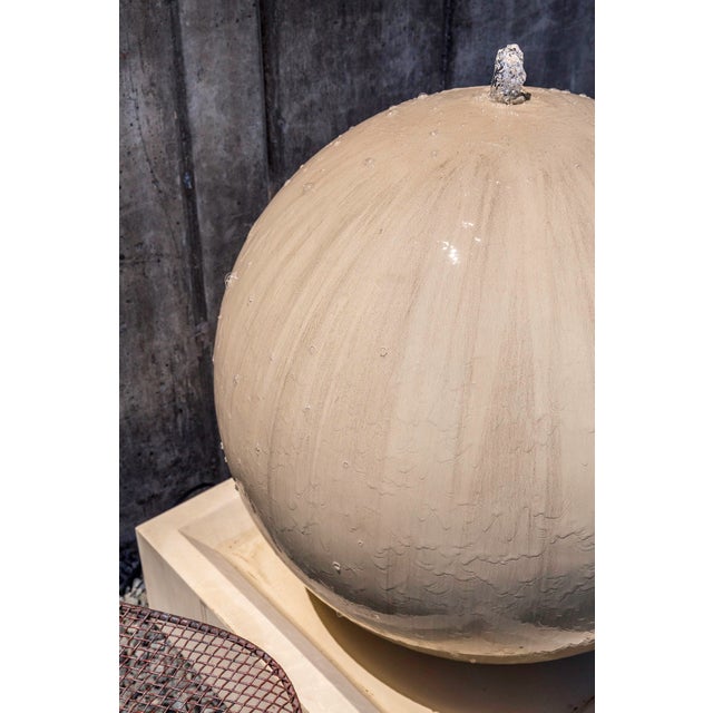 A spherical, freestanding fountain of Glass Fiber Reinforced Concrete (GFRC) with a French Limestone finish.