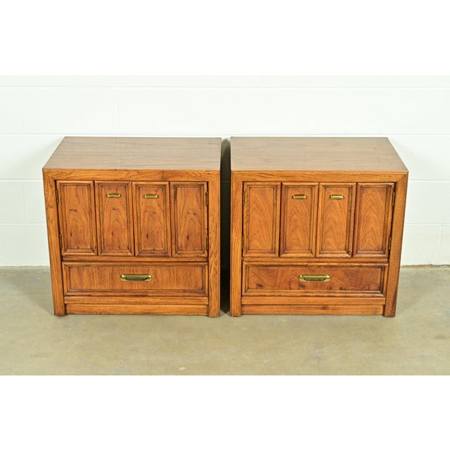 An exceptional pair of Mid-Century Modern Hollywood Regency Campaign style nightstands or end tables By Thomasville USA,...