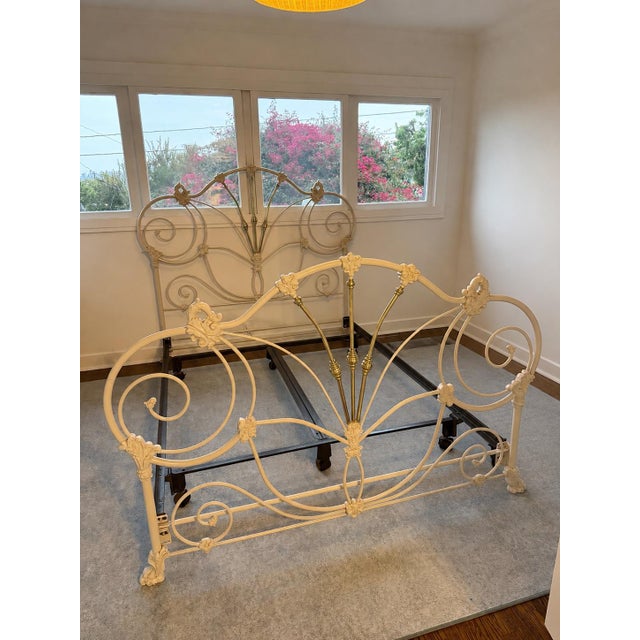Headboard, footboard, + bed frame with ornate scrollwork and floral detailing. Finished in a soft ivory/cream color with...