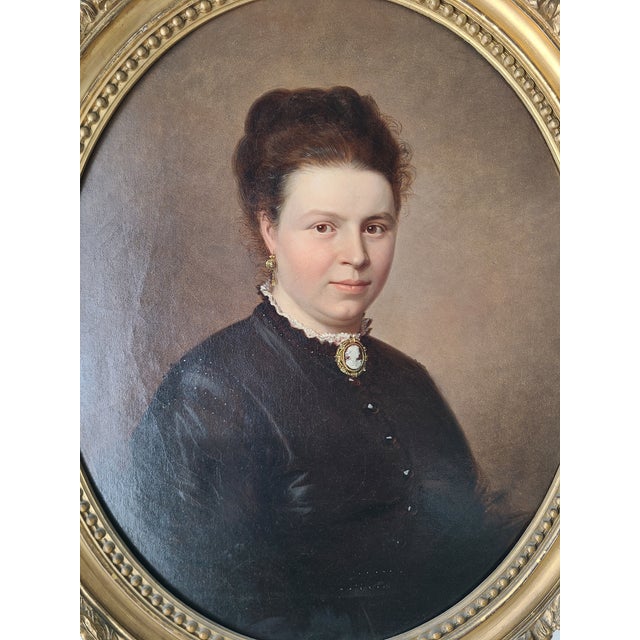 Skillful and elegant mid-19th century oil painting of a woman in black with a cameo. Original and one of a kind. The...