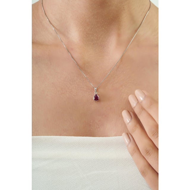 The Dainty Pear-Cut 0.82 Ct Ruby Bezel-Set Solitaire Pendant features a striking 0.82-carat Ruby in a graceful 5 x 7 mm...