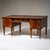 Bureau plat veneered in thuya burl, raised on eight tapered square legs with brass sabots and fitted with five drawers....
