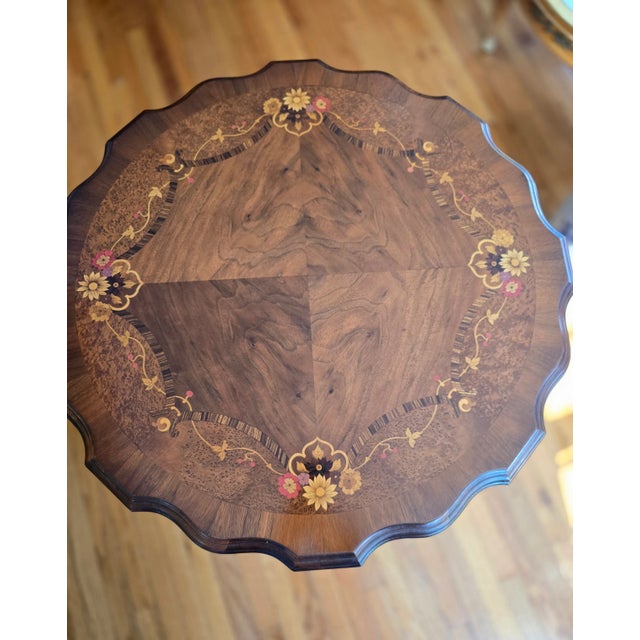 This vintage elegant round table showcases artisanal craftsmanship with intricate floral inlay with exotic woods on the...