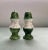 A pair of salt and pepper shakers in a colonial revival shape with a green foot and top and a rainbow speckled white glaze...