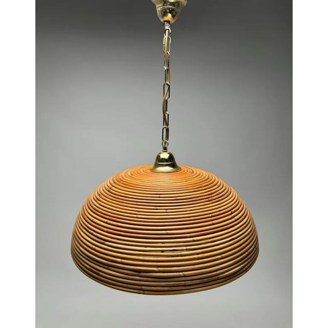 Eyecatching Italian 1960s handcrafted rattan pendant light with circular design. This suspension lamp has a bell shaped...