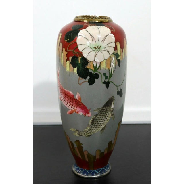 A stunning vintage vase that is made with enameled cloisonne. The design is depicting a lovely koi fish imagery. In...