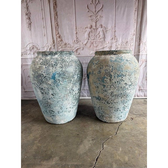 An impressive pair of large vintage like terracotta garden urns featuring a beautifully aged distressed patina in soft...