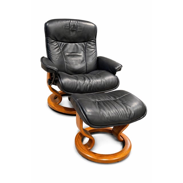 DESCRIPTION: Classic Ekornes Stressless recliner with matching ottoman in black leather. Clean, high-back profile with...