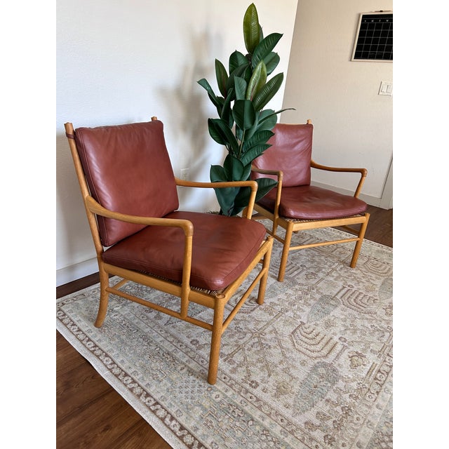 A matching pair of Ole Wanscher OW149 Colonial Chairs by Carl Hansen & Son, made in Denmark in 2018. Solid oak frames with...