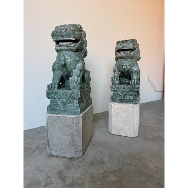 A striking pair of large vintage Chinese Foo Dog (Shi Shi) guardian sculptures finely hand-carved from natural green...