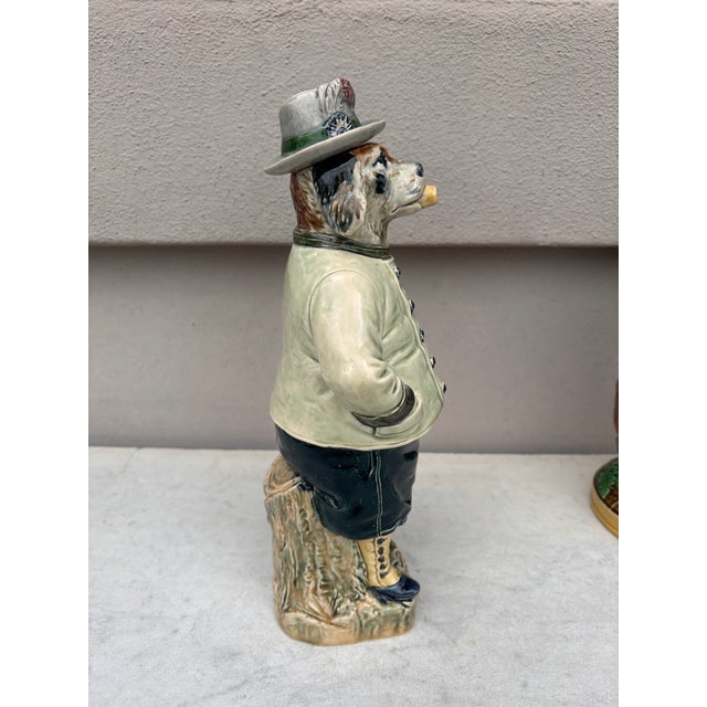 Majolica German figural dog bottle, circa 1890. The bottle represent a dog in hunting costume smoking a pipe and carrying...