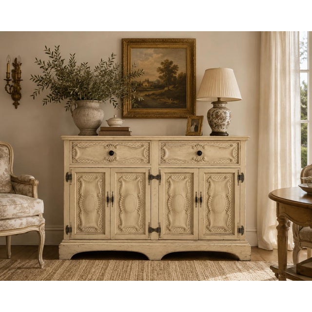 Charming vintage French Provincial-style wooden sideboard or buffet cabinet featuring an aged, distressed cream/off-...