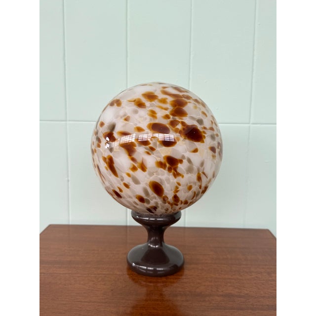 Blown glass sphere decorated with multicolored spots. It features a label with Alain Delon's monogram and signature. A...