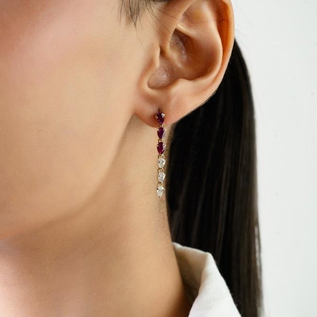 These handcrafted drop earrings feature 6 pear shape natural rubies totaling 1.32 carats, set in 14k yellow gold. The...