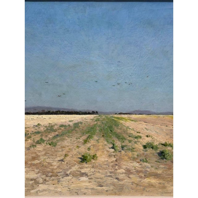 A beautiful French landscape from the late 19th century, capturing a vast, sunlit field beneath a clear blue sky. With...
