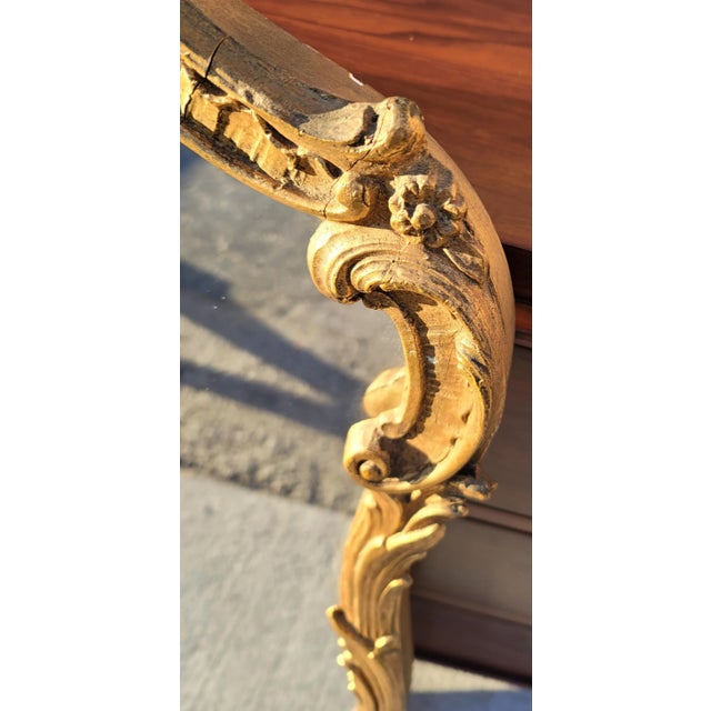 Featured is a vintage hand carved gilt mirror by Friedman Brothers Decorative Arts Inc. Retains a fragment of maker's...