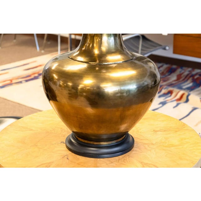 A pair of large brass mid century modern table lamps. These beautiful vintage lamps feature a brass finish with a domed...