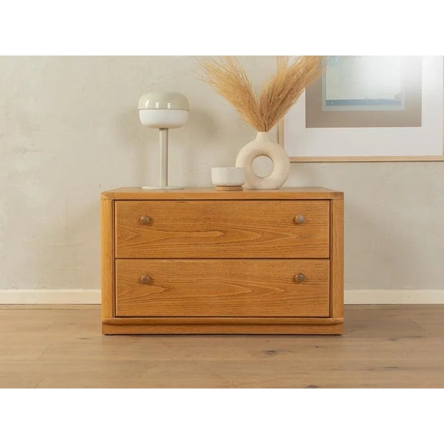 Classic chest of drawers from the 1980s. Body in oak veneer with two drawers and original base. Quality features: very...