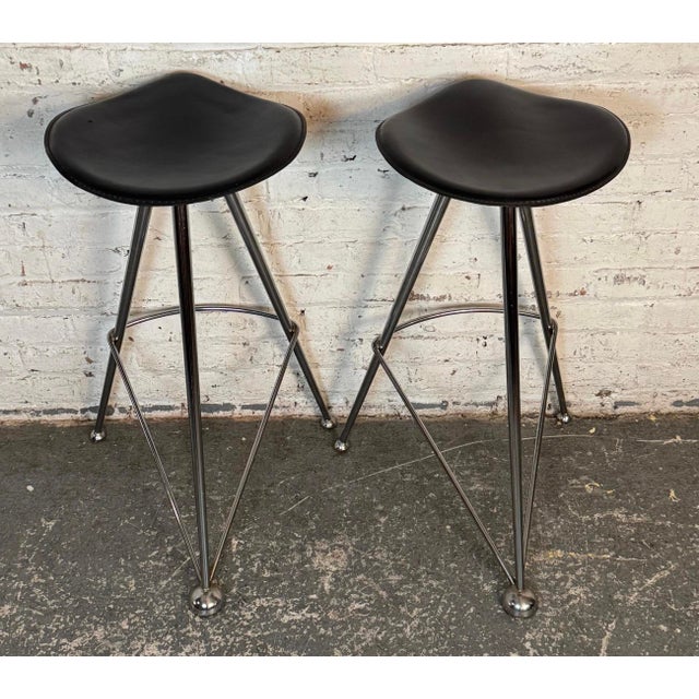 Pair of vintage modern chrome bar stools with black seats. Triangular frames and sculpted seating make these atomic space...