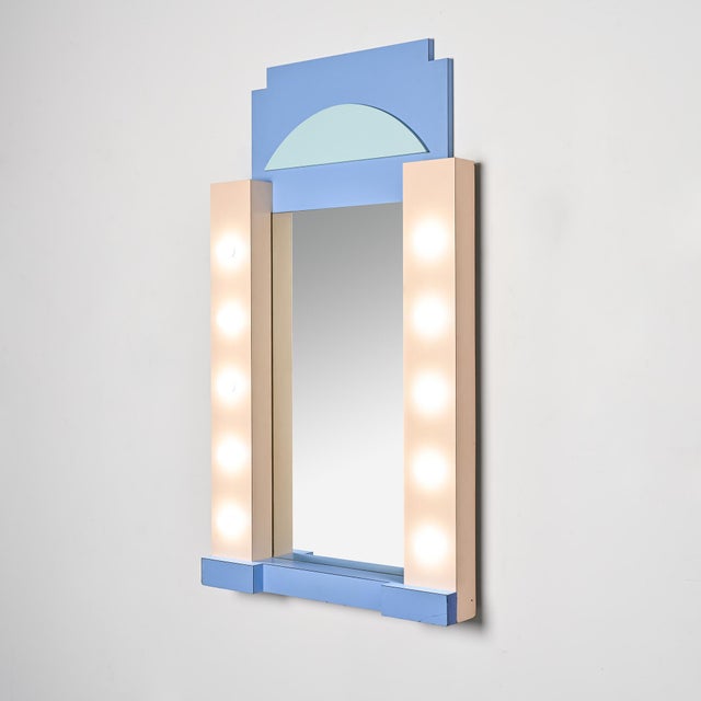 Wall mirror with an architecturally structured frame in polychrome laminated wood, characteristic of decorative designs...