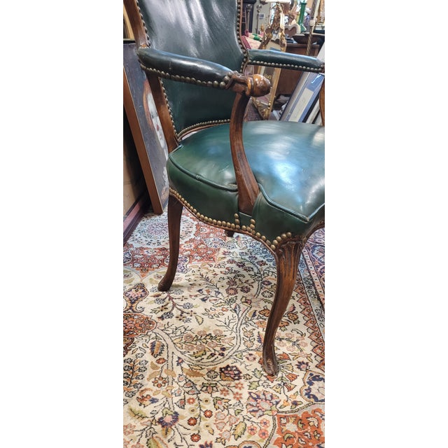 Fine antique forest green leather French arm chair. Features original green leather upholstery brass tacks and a French...