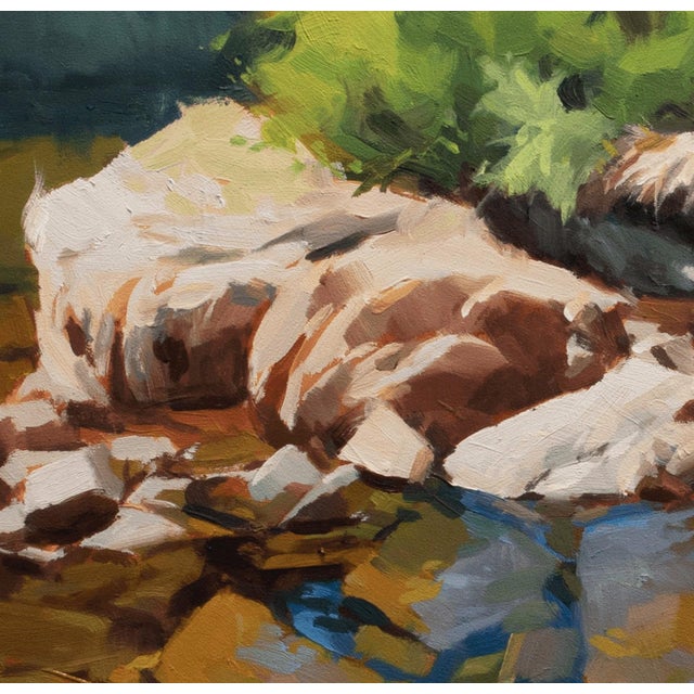 This oil painting captures a serene landscape where sunlight dances across a rocky shoreline, reflecting vibrant hues in...