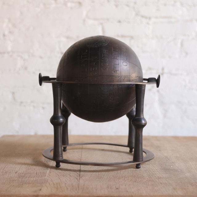 This 1950s Belgian bronze globe combines sculptural form and mid-century character with a beautifully aged patina and...