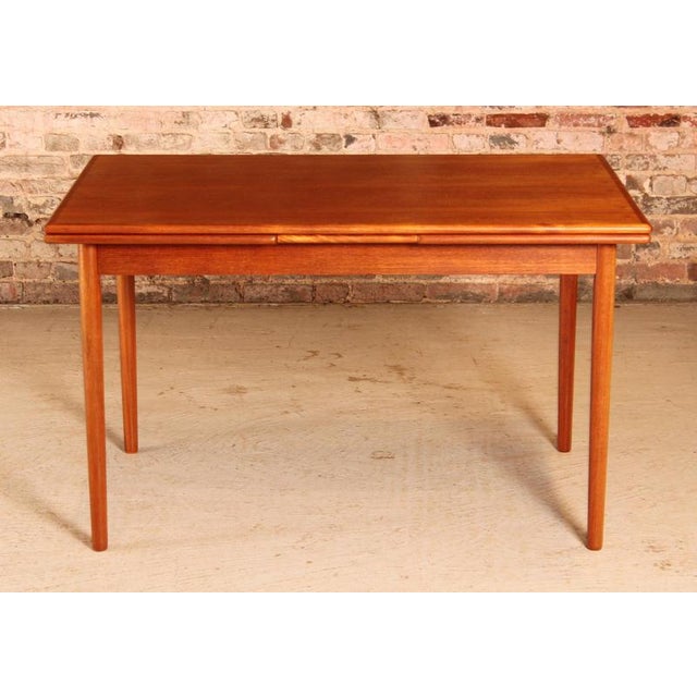 Danish Mid Century extending teak dining table, circa 1970s. 2 extension leaves stored underneath. Excellent restored...