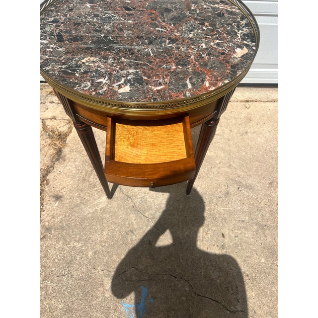 Elegant French Louis XVI side table crafted in walnut with a beautifully figured veneer. It features a single drawer, a...