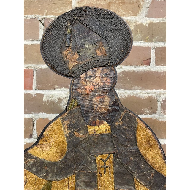 This relief plaque depicts a Holy Bishop or Saint detailed in carved wood, standing in a traditional blessing posture and...