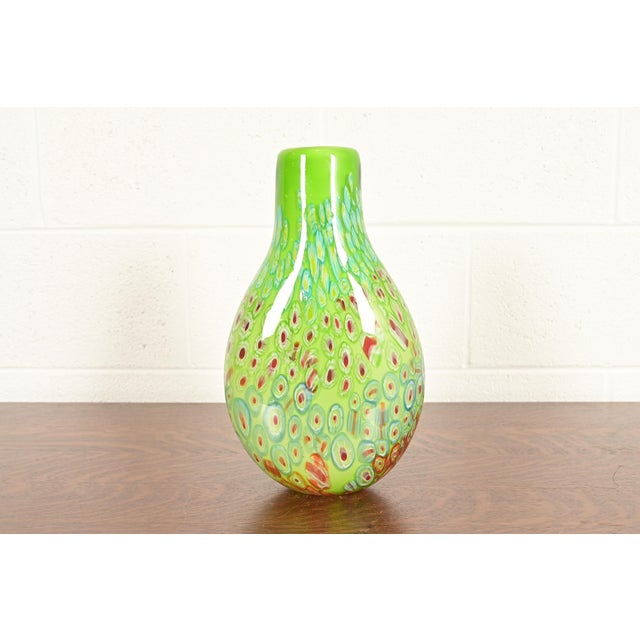 A gorgeous Italian Murano glass vase featuring a distinctive Millefiori pattern with lime green and red swirls By Ann...