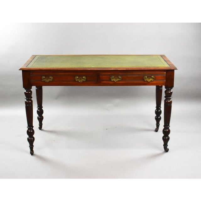 An Edwardian mahogany writing table in the Georgian revival taste, having a rectangular top above a pair of opposing...