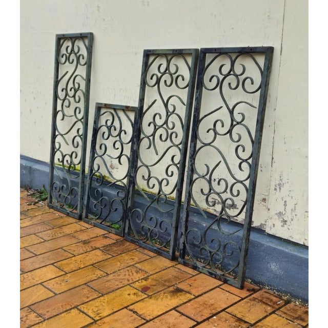 Set of four decorative wrought iron panels, 20th century Set of four wrought iron panels featuring an elegant design of...