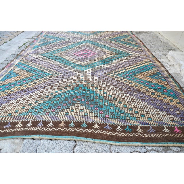 This is a vintage Turkish Anatolian kilim rug from the 1960s. The piece was hand-woven.