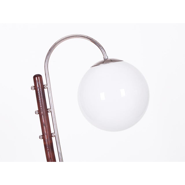 An iconic model by J. Halabala, produced in the 1930s. The lamp combines dark-stained wood with an opal glass globe and...