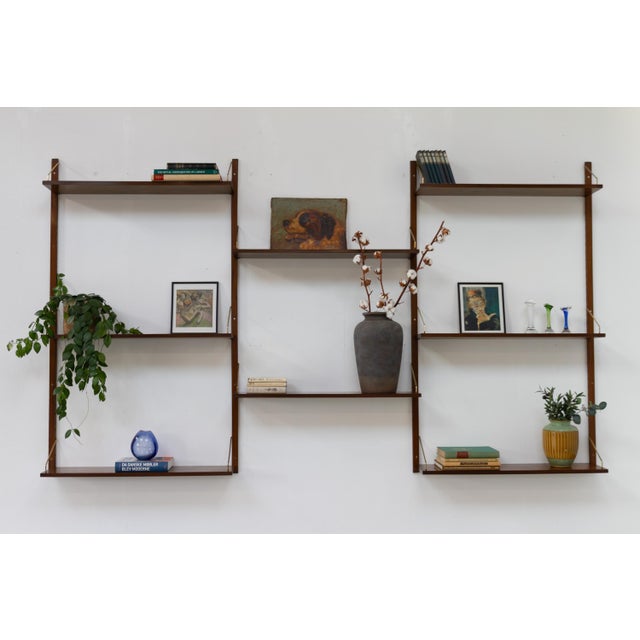 This is an early version of the Royal wall unit by Poul Cadovius with beautiful stained walnut veneered shelves. Designed...