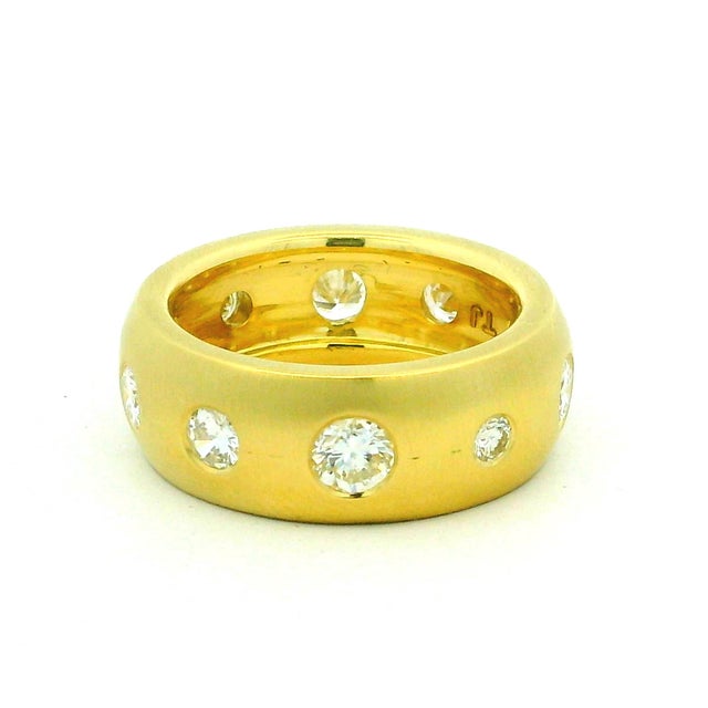 A substantial 18K gold band set with ten brilliant-cut diamonds, totaling approximately 1.90 carats. Each stone is...