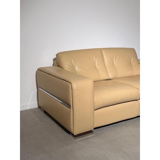 Elegant italian-made two-seater sofa upholstered in soft beige leather. A comfortable, generously proportioned design...