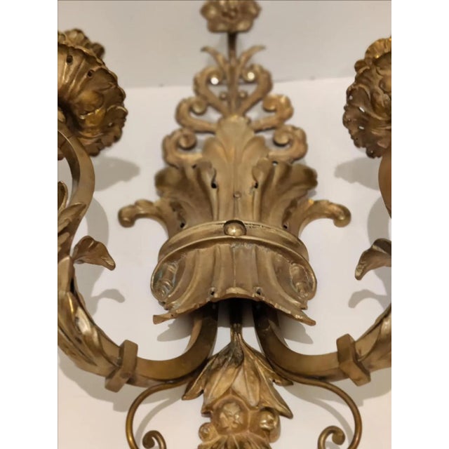 A magnificent pair of ornate patinated brass non-electrified wall sconces. These stunning Italian sconces are designed...