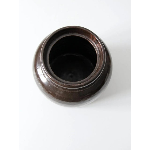 This antique stoneware storage jar is attributed to Red Wing and dates to the late 19th to early 20th century. The rounded...