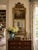 An unusually elegant late 19th century French trumeau mirror combining carved giltwood, antiqued mirror glass, and a...