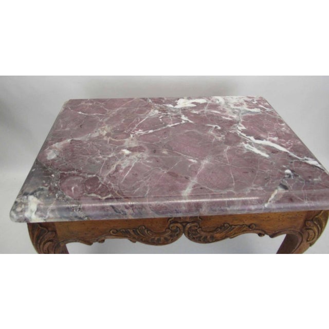 An elegant French Louis XV style low table, featuring a beautifully veined, rectangular marble top with softly molded...