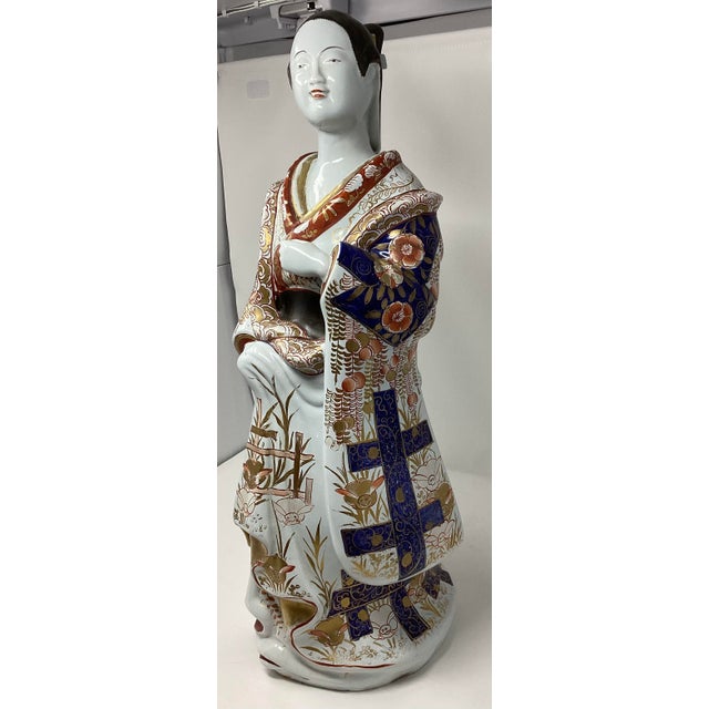 Modeled in draped robes, embellished with fenced rabbits. Signed by artist inside base.