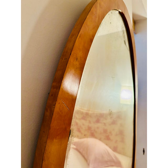 This antique Biedermeier mirror is oval in form. The antique mirror glass has a lovely beveled edge all the way around,...