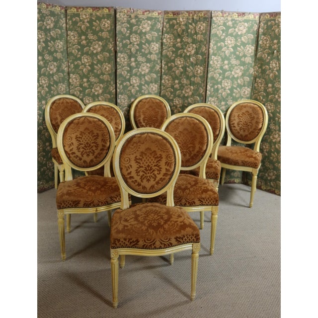 Set of eight Louis XVI style chairs in painted wood, upholstered in rust-colored velvet. DIMENSIONS: 0.48m wide, 0.43m...