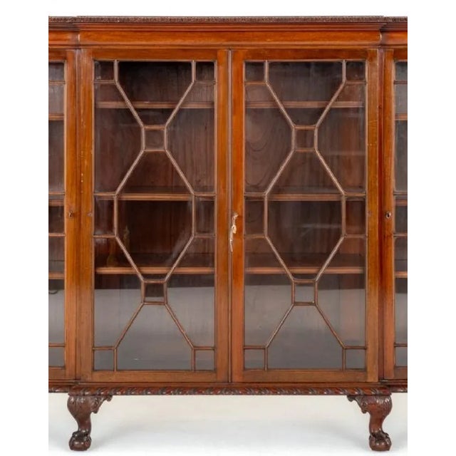 Impressive mahogany Chippendale style 4 door breakfront bookcase. This quality 4 door bookcase stands upon a squat...