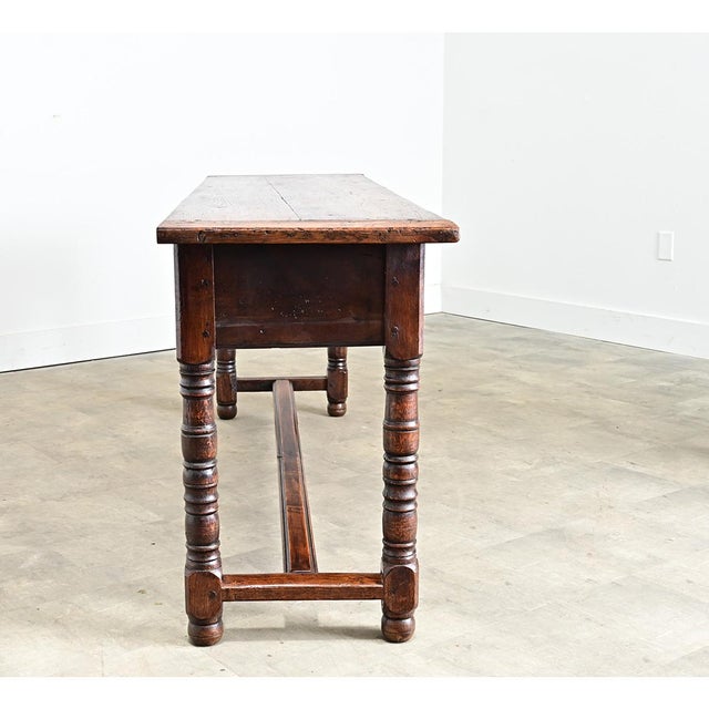 A substantial console table/server from 19th century France, handcrafted from solid oak that exhibits the impressive...