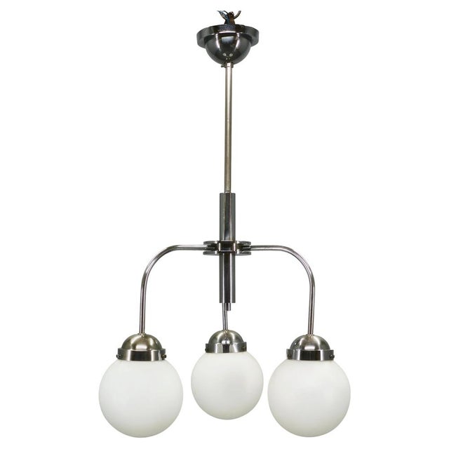Rare bauhaus chandelier produced in czechoslovakia during the 1940s. This refined modernist lighting fixture combines a...